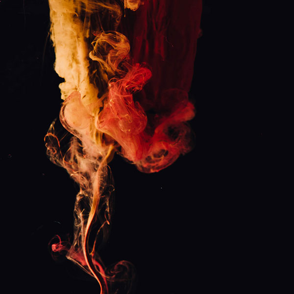 Farbwolke von oben nach unten in den Farben gelb und rot auf schwarzem Hintergrund